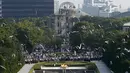 Burung Merpati terbang di atas Peace Memorial Park, dengan latar Monumen Bom Atom, pada saat upacara peringatan 70 tahun jatuhnya bom atom di Hiroshima, Jepang (6/8/2015). 140.000 penduduk Jepang tewas akibat Bom Atom. (REUTERS/Toru Hanai)