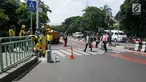 Pejalan kaki menyeberang di zebra cross kawasan Pinang Ranti, Jakarta, Senin (11/2). Zebra cross yang berada di samping Tamini Square itu sempat jadi perbincangan lantaran terhalang oleh pagar besi hijau setinggi 1 meter. (Liputan6.com/Herman Zakharia)