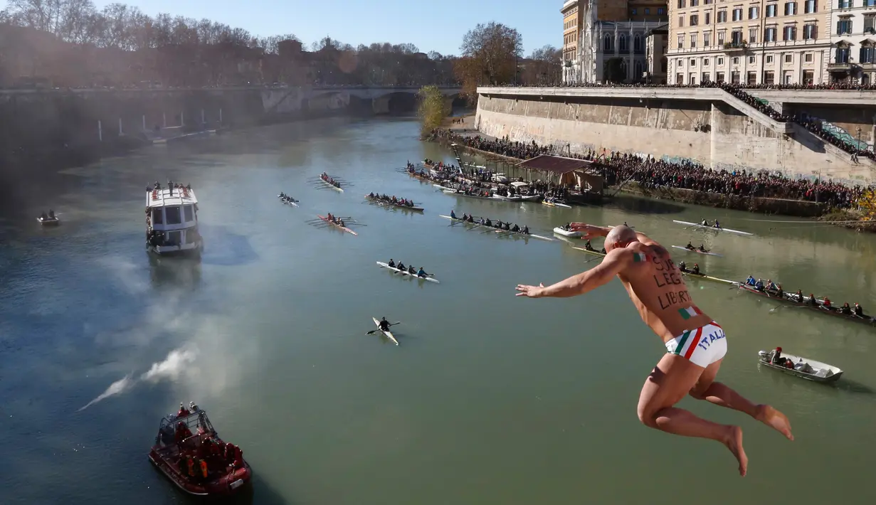 Simone Carabella dari Italia melakukan terjun bebas ke sungai Tiber dari Jembatan Cavour di Roma, Selasa (1/1). Tradisi melompat dari jembatan setinggi 18 meter  dan menyelam ke sungai tersebut sebagai bentuk perayaan tahun baru. (AP/Riccardo De Luca)