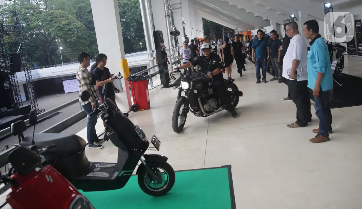 Pengunjung melihat motor modifikasi saat dikendarai dalam pemeran IIMS Motobike Expo 2019 di Istora Senayan, Jakarta, Jumat (29/11/2019). IIMS Motobike Expo 2019 digelar pada 29 November-1 Desember 2019. (Liputan6.com/Faizal Fanani)