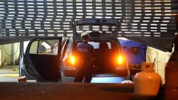 Petugas memeriksa mobil usai seorang pria dengan tabung gas di kendaraannya menabrak pintu gerbang markas polisi Merrylands, Sydney Barat, Kamis (21/7). Pria itu dilarikan ke RS dalam kondisi serius setelah kendaraannya terbakar (AAP/Sam Mooy via REUTERS)