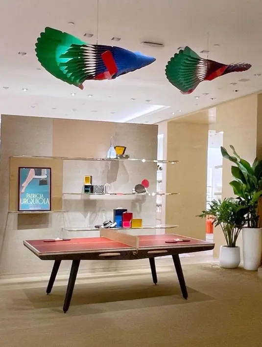 Hiasi langit-langit ruangan dengan Quetzal Mobile By Atelier Oï seharga IDR 170.000.000. Hiasan gantung besar yang terinspirasi oleh bulu burung quetzal Amerika Selatan ini begitu menarik perhatian. Tiga belas "bulu" yang kaku namun meliuk ditutupi dengan dua lembar kulit Louis Vuitton – biru di satu sisi dan hijau di sisi lainnya – dan tepinya diwarnai merah. Bulu terakhir, yang lebih panjang untuk memberikan keseimbangan pada hiasan gantung, ditutupi dengan kulit merah, dan mengingatkan pada dada burung berwarna merah terang. Menggantung dengan bulu-bulunya yang terbuka seperti sayap berwarna cerah, Quetzal merupakan hiasan gantung yang elegan sekaligus gambaran abstrak yang indah dari seekor quetzal yang sedang terbang. Cocok diletakkan di atas meja ping pong yang dibalut kulit monogram khas Louis Vuitton.  / Foto dok: Louis Vuitton.