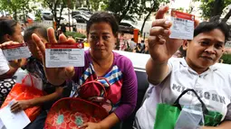 Sejumlah warga menunjukkan Kartu Keluarga Sejahtera saat menunggu antrean dana bantuan Program Simpanan Keluarga Sejahtera (PSKS) di Kantor Pos Pasar Baru, Jakarta, Selasa (7/4/2015). (Liputan6.com/Johan Tallo)