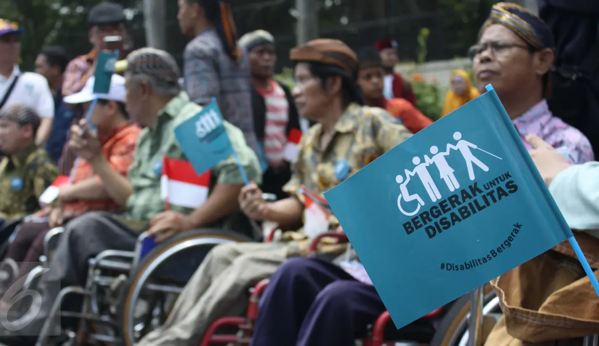 Penyandang disabilitas memegang bendera bertuliskan “bergerak untuk disabilitas” saat mengikuti Karnaval Budaya Disabilitas di kawasan Bundaran HI, Jakarta, Selasa (18/08/2015). (Liputan6.com/Gempur M Surya)  