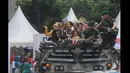 Sejumlah pasangan pengantin yang menaiki panser TNI AD, melakukan prosesi arakan pengantin saat Resepsi Penikahan Massal Pengantin se-Jabodetabek di Istora Senayan, Jakarta, Rabu (28/1/2015). (Liputan6.com/Herman Zakharia)