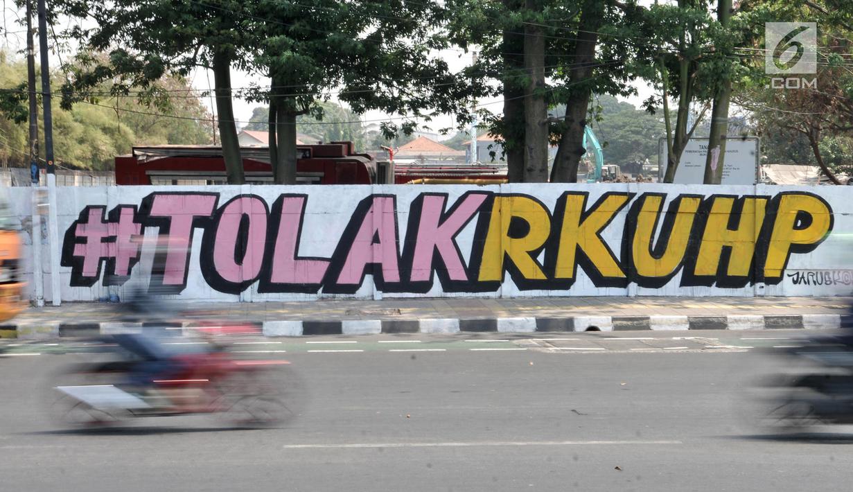Mural bertulis '#TolakRKUHP' terpampang pada dinding di Jalan Pemuda, Rawamangun, Jakarta, Selasa (1/10/2019). Mural tersebut respons dari seniman Jakarta terhadap RUU KUHP yang dinilai mencederai tatanan demokrasi. (merdeka.com/Iqbal Nugroho)