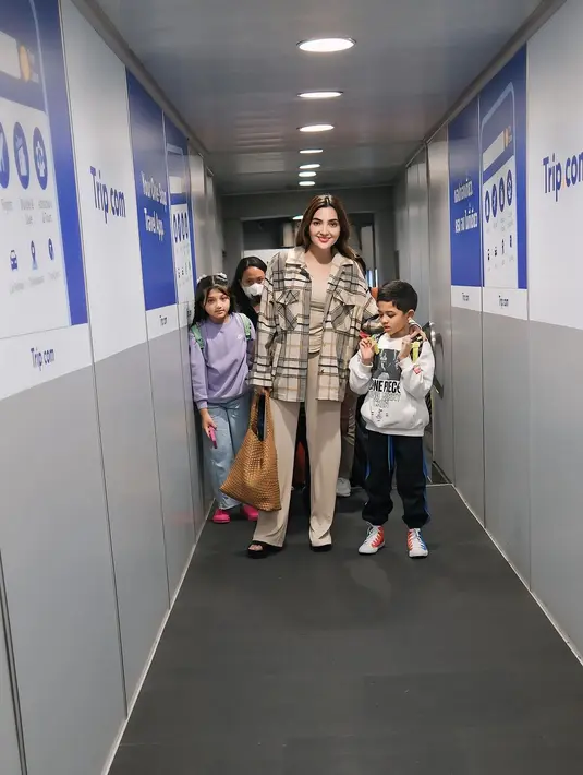 Ashanty jadi cewek bumi dengan outfit serba cokelat-nude. Ia padukan kemeja flanel dengan tanktop dan celana nude [@ashanty_ash]