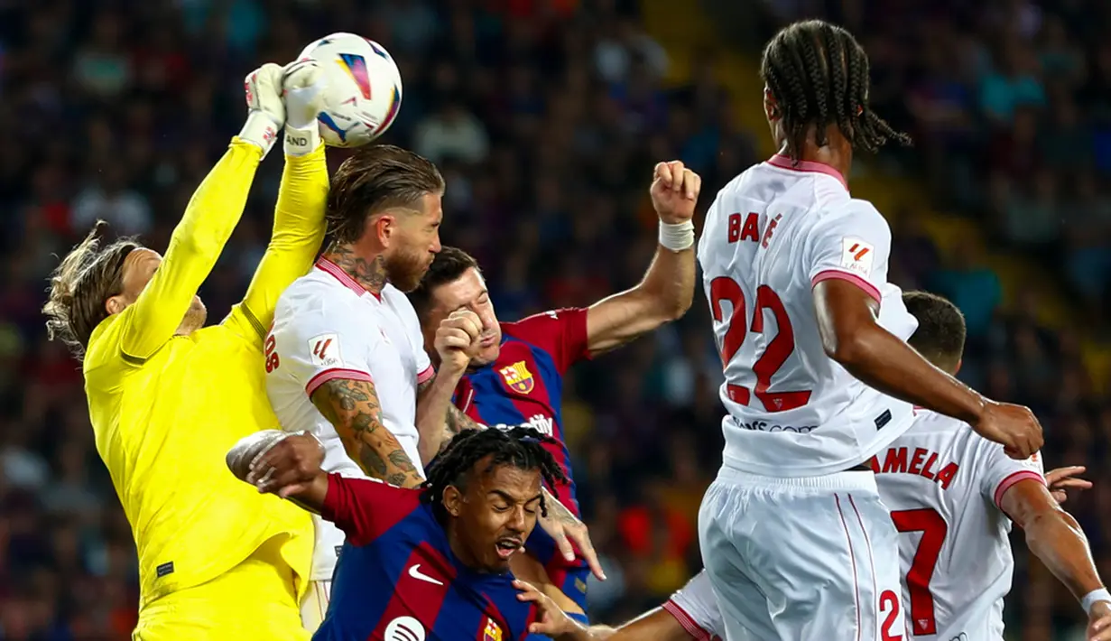 Barcelona kembali ke jalur kemenangan di Liga Spanyol 2023/2024. Barca menang 1-0 atas tamunya Sevilla berkat gol bunuh diri bek senior Sergio Ramos. (AP Photo/Joan Monfort)