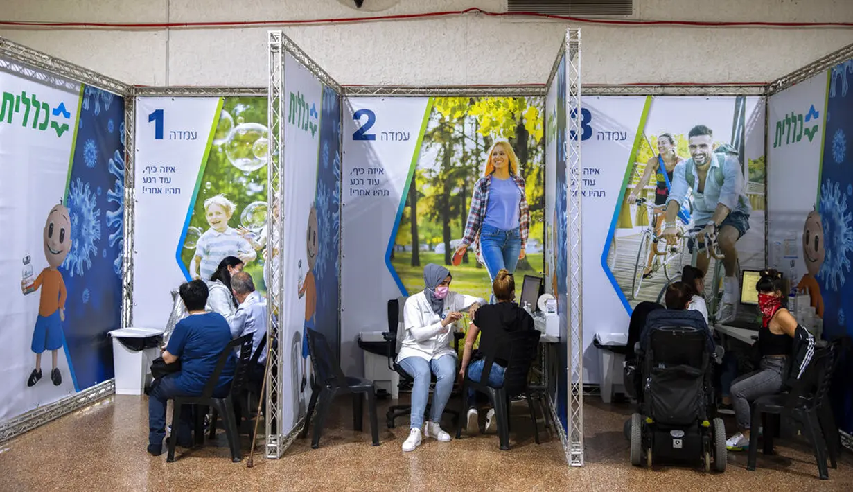 Orang-orang menerima vaksin virus corona COVID-19 di Pusat Vaksinasi COVID-19, Ramat Gan, Israel, Minggu (3/1/2021). Capaian vaksinasi di Israel merupakan yang tertinggi di dunia untuk saat ini. (AP Photo/Oded Balilty)
