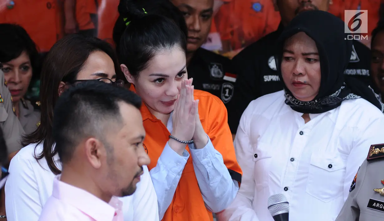 Artis peran dan model, Jennifer Dunn mengangkat tangan saat diperlihatkan usai penangkapan di Dirnarkoba Polda Metro Jaya, Jakarta, Selasa (2/1). Polisi menyita 0,6 gram sabu dan sejumlah telepon genggam. (Liputan6.com/Helmi Fithriansyah)