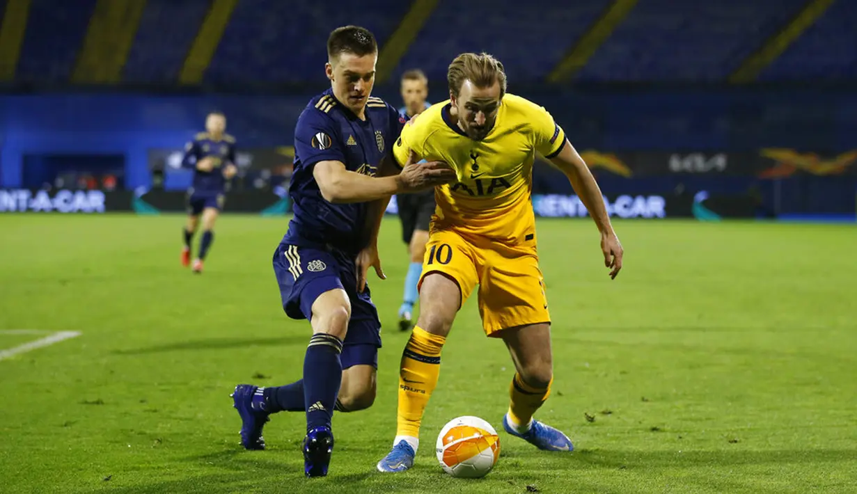 Pemain Tottenham Hotspur Harry Kane (kanan) memperebutkan bola dengan pemain Dinamo Zagreb Rasmus Lauritsen pada pertandingan leg kedua babak 16 besar Liga Europa di Stadion Maksimir, Zagreb, Kroasia (18/3/2021). Tottenham kalah 0-3, sehingga agregat 2-3. (AP Photo/Darko Bandic)