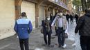 Orang-orang berjalan di depan toko-toko yang tutup di Grand Bazaar Teheran saat polisi anti huru-hara mengontrol lokasi protes, Iran, Selasa (15/11/2022). Etalase toko yang tertutup dapat dilihat di seluruh Teheran, pada hari Selasa. (AP Photo/Vahid Salemi)