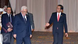 Presiden Palestina Mahmoud Abbas tersenyum ketika berbincang dengan Presiden RI, Jokowi (kanan) sesaat sebelum foto bersama peserta KTT Luar Biasa Organisasi Kerja sama Islam (OKI) di Jakarta Convention Center, Senin (7/3). (Liputan6.com/Faizal Fanani)