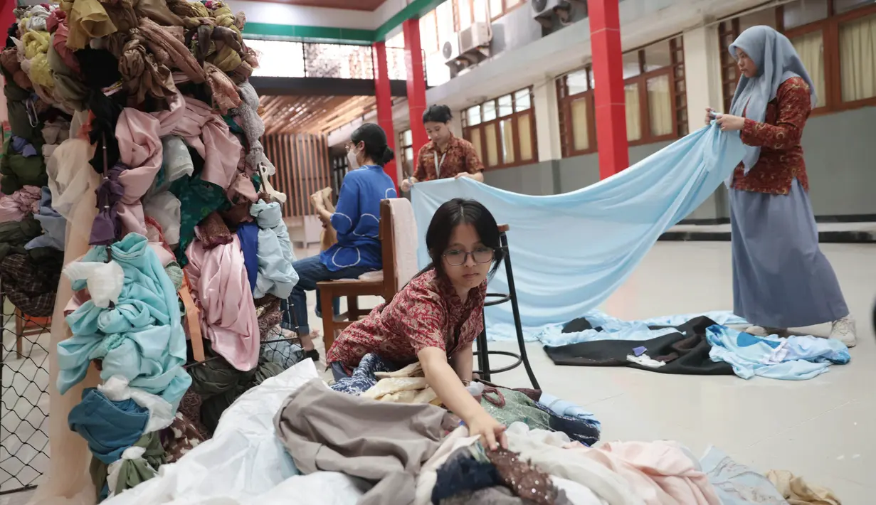 Sejumlah siswa SMA Labschool Kebayoran, Jakarta Selatan, membuat kreatifitas untuk dekorasi panggung menggunakan potongan kain tekstil tak terpakai untuk menjadi bagian dari panggung pensi Skyavenue 2026, Kamis (23/7/2026). (KLY/ Budy Santoso)