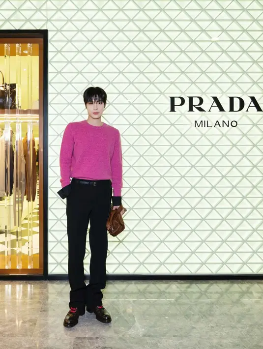 Hwang In-Youp hadir dengan tampilan memikat. Vibrant pink knit sweater yang dipadukan dengan celana hitam tas Prada leather sling bag berwarna cokelat. / Foto dok Prada.