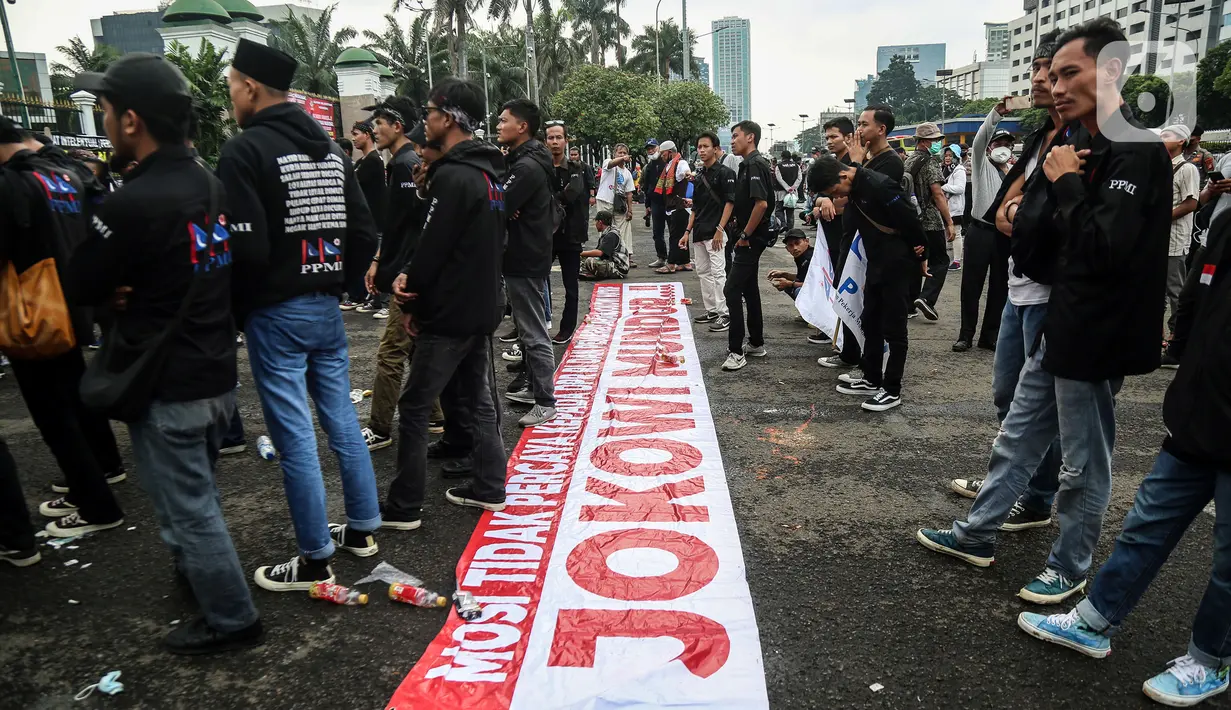 Demonstran membentangkan spanduk berisi pesan tuntutan saat berunjuk rasa di depan Gedung MPR/DPR/DPD, Jalan Gatot Subroto, Jakarta, Jumat (20/5/2022). Demonstran menuntut berbagai isu, di antaranya Omnibus Law dan penurunan harga sembako serta bahan bakar minyak (BBM). (Liputan6.com/Johan Tallo)
