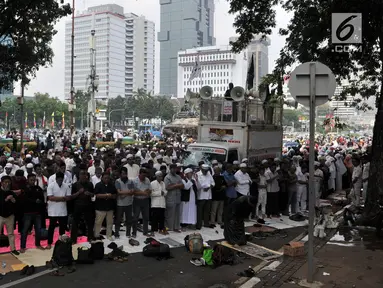 Massa salat berjemaah saat menggelar aksi di sekitar Patung Kuda, Monas, Jakarta, Rabu (26/6/2019). Ratusan massa terus memadati aksi tersebut untuk menuntut hakim MK agar adil dalam memutuskan hasil sidang sengketa Pilpres 2019. (merdeka.com/Iqbal S. Nugroho)