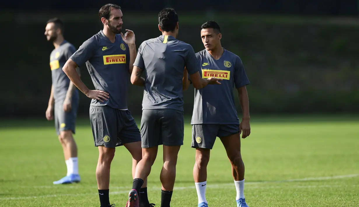 Bek Inter Milan, Diego Godin (kiri) berbincang dengan Antonio Candreva dan Alexis Sanchez selama sesi latihan tim di Appiano Gentile, Italia (16/9/2019). Inter Milan akan bertanding melawan Slavia Praha pada grup F Liga Champions di Giuseppe Meazza, Italia. (AFP Photo/Miguel Medina)