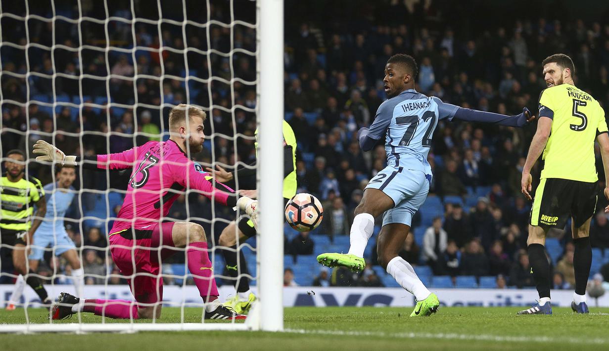 Pemain Manchester City, Kelechi Iheanacho (tengah) mengecoh kiper Huddersfield Town dengan golnya pada laga Piala FA putaran kelima di Etihad stadium, Manchester, Wednesday, (1/3/2017). Man.City menang 5-1. (AP/Dave Thompson)