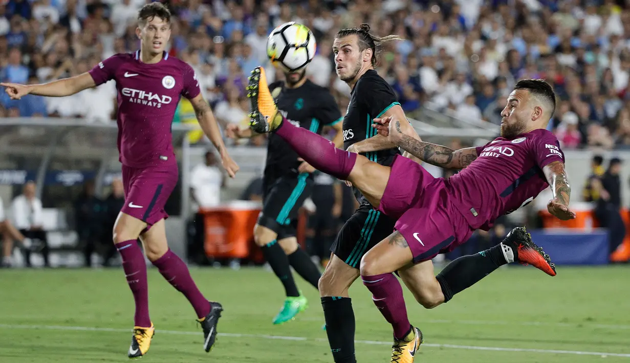 Penyerang Real Madrid, Gareth Bale berusaha mengejar bola dari hadangan bek Manchester City, Nicolas Otamendi pada pertandingan ICC di Los Angeles Memorial Coliseum, Kamis (27/7). City menang atas Madrid dengan skor 4-1. (AP Photo/Jae C. Hong)