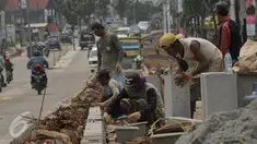 Pekerja saat menyelesaikan proyek rehabilitasi ruas jalan Ciputat-Pamulang, Tangerang Selatan, (28/1). Pemerintah Provinsi Banten akan melakukan rehab pada beberapa titik ruas jalan yang menghabiskan lebih dari Rp 21 miliar. (Liputan6.com/Faisal R Syam)