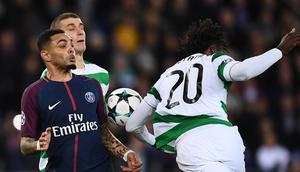 Bek Celtic, Dedryck Boyata berebut bola dengan pemain Paris Saint-Germain, Layvin Kurzawa dalam lanjutan fase grup Liga Champions di Parc des Princes, Kamis (23/11). PSG menunjukkan keperkasaannya dengan melumat Celtic 7-1. (FRANCK FIFE / AFP)