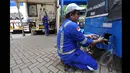 Seorang petugas Stasiun Bahan Bakar Gas (SPBG) mengisi bahan bakar ke salah satu bajaj yang memakai bahan bakar gas di kawasan Monas, Jakarta, Senin (26/1/2015). (Liputan6.com/Miftahul Hayat)
