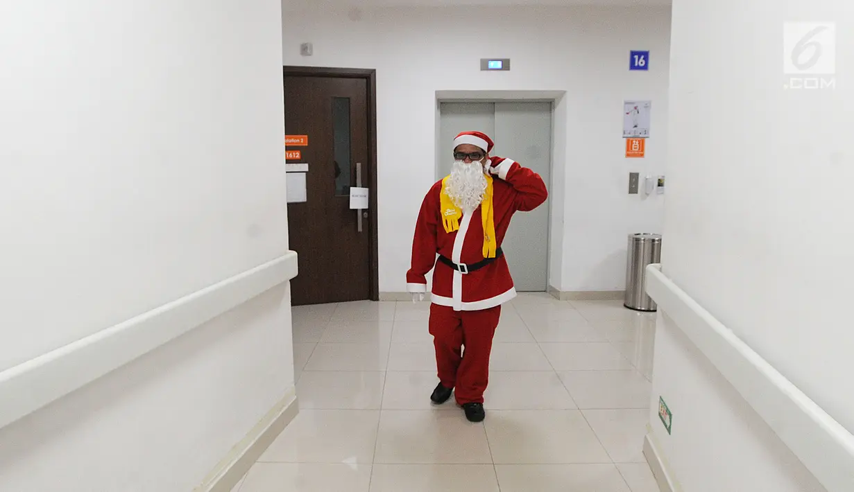Seorang pria mengenakan kostum Santa Claus berjalan di RS Siloam, TB Simatupang, Jakarta, Kamis (21/12). Kegiatan ini dalam rangka menyambut perayaan Hari Natal 2017. (Liputan6.com/Joan)