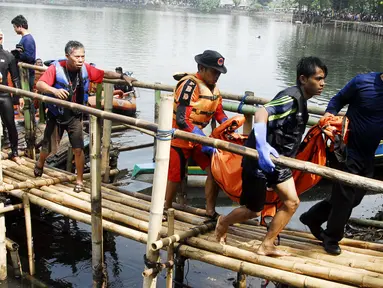 Tim penyelamat mengangkat jenazah salah satu korban perahu tenggelam di Setu Cikaret, Cibinong, Bogor, Jabar, (4/8/2014). (ANTARA FOTO/Jafkhairi)