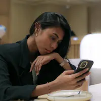 Menggunakan ponsel./Copyright Fimela - Daniel Kampua