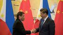 Presiden Filipina Rodrigo Duterte berjabat tangan dengan Presiden Xi Jinping seusai pertemuan dua negara di Beijing (20/10). Pertemuan tersebut membuat kebijakan luar negri Filipina yang lebih condong ke Tiongkok daripada ke AS. (Reuters/ Ng Han Guan)