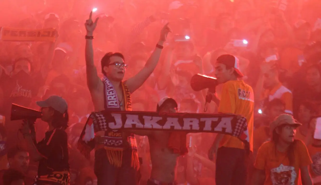 Pendukung Persija Jakarta, The Jakmania, merayakan hari jadi klub kesayangannya dengan menyaksikan laga Piala Jenderal Sudirman melawan Arema Cronus di Stadion Kanjuruhan, Malang, Sabtu (28/11/2015). (Bola.com/Robby Firly) 