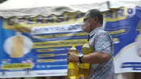 Seorang pria membawa minyak goreng yang dibelinya di Polsek Tebet, Jakarta Selatan, Jumat (4/3/2022). Polres Metro Jakarta Selatan akan menggelar operasi pasar minyak goreng selama enam hari, terhitung mulai hari in, 4 hingga 9 Februari mendatang. (Liputan6.com/Herman Zakharia)