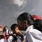 Anak-anak menaiki mobil saat terjadi erupsi Gunung Sinabung di sekolah dasar Sipandak di desa Tiga Pancur di Karo, Sumatra Utara (19/2). Gunung Sinabung aktif kembali tahun 2010 untuk pertama kalinya dalam 400 tahun terakhir. (AFP Photo/Anto Sembiring)