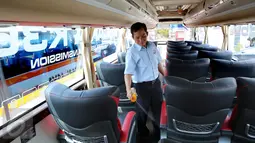 Petugas menyemprot pengharum ruangan di dalam Bus Harapan Jaya, di Pool Ciputat, Tangerang Selatan. Bus bermesin Scania K360IB 4x2 memiliki kapasitas mesin 13.000 cc dan 360 horse power. (Liputan6.com/Fery Pradolo)