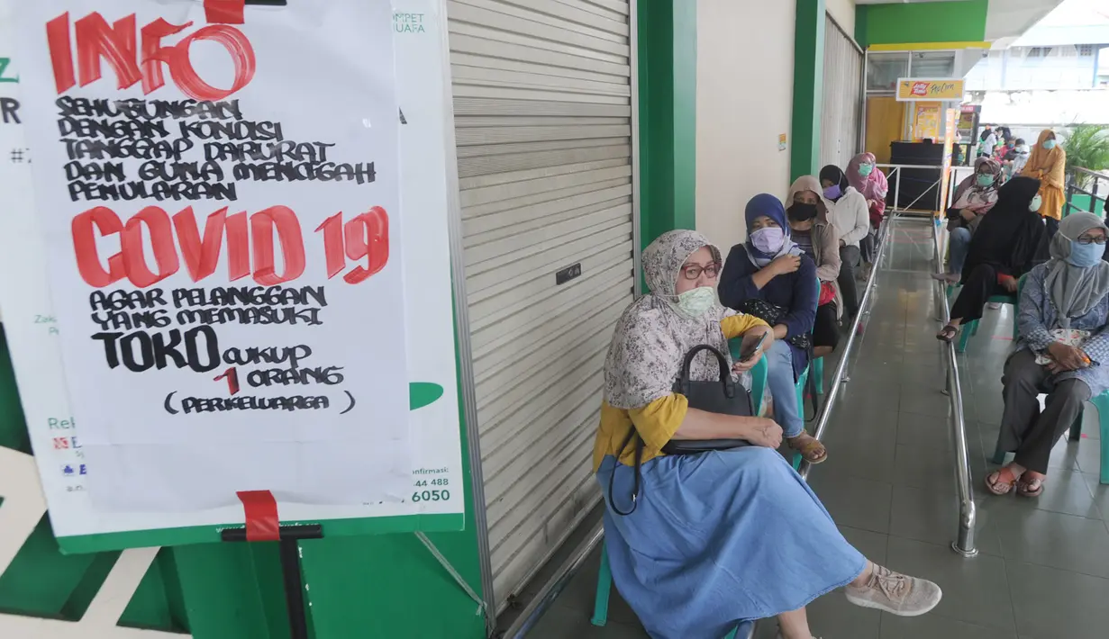 Pengunjung antre dengan menjaga jarak fisik (Physical Distancing) saat menunggu supermarket buka di kawasan Ciputat, Tangerang Selatan, Selasa (14/4/2020). Pemerintah terus mengimbau warga untuk melakukan jarak fisik sebagai tindakan pencegahan penyebaran Corona COVID-19. (merdeka.com/Arie Basuki)