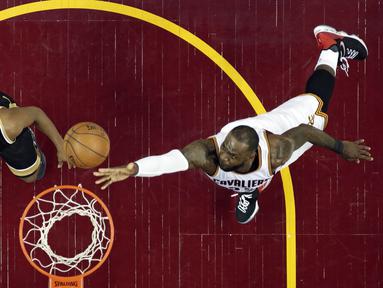Aksi LeBron James (kanan) memasukan bola melewati adangan pemain Toronto Raptors, Kyle Lowry pada Game 2 pada semifinal Eastern Conference NBA basketball playoff series di Quicken Loans Arena, (3/5/2017). Cavs menang 125-103. (AP/Tony Dejak)