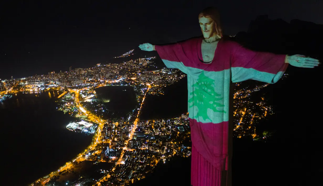 Patung Christ the Redeemer terlihat diterangi dengan bendera nasional Lebanon di Rio de Janeiro, Brasil, Kamis (6/8/2020). Tindakan tersebut sebagai bentuk solidaritas bagi para korban ledakan dahsyat yang mengguncang ibu kota Lebanon, Beirut pada Selasa (4/8) lalu. (AP Photo/Leo Correa)