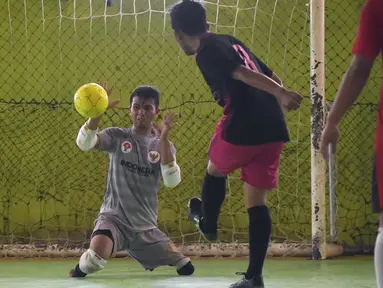 Seorang kiper, Eman Sulaeman berusaha menangkap bola saat pertandingan futsal di Indramayu, Jawa Barat, 3 Februari 2018. Pada 2016 lalu, Eman mengikuti Homeless World Cup di Glasgow dan dinobatkan sebagai kiper terbaik dalam ajang itu. (ADEK BERRY/AFP)