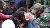 Tim gabungan yang bertugas menyelamatkan  dua petugas kemanan yang terjebat diantara puing-puing reruntuhan kantor Gubernur Sulbar berhasil mengevakuasi mereka dalam keadaan hidup. (Liputan6.com/Abdul Rajab Umar)