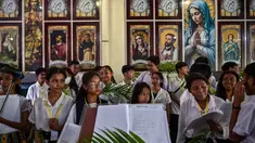 Paduan suara gereja Katolik mempersiapkan daun palem selama prosesi untuk menandai Minggu Palem di Gereja Kelahiran Bunda Maria, yang juga dikenal sebagai Gereja Katolik Kelahiran Santa Perawan Maria, di Surabaya pada 13 April 2025. (JUNI KRISWANTO/AFP)