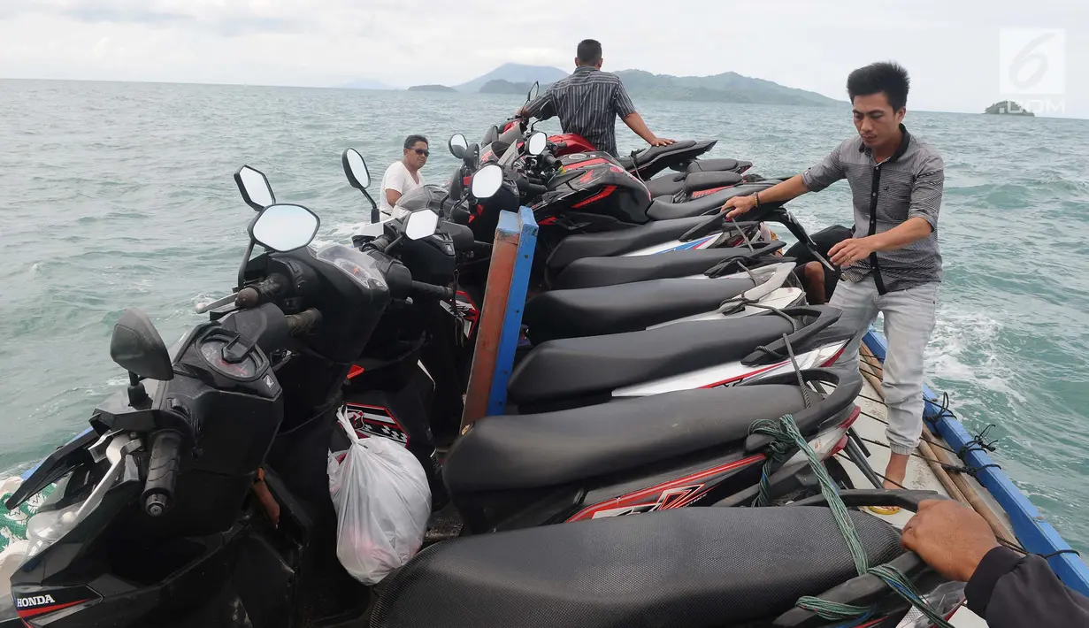 Petugas menata motor di atas kapal  ketika menyeberang dari pelabuhan Pulau Sebesi, Lampung, Senin (31/12). Setiap harinya hanya ada satu kapal yang menyeberang pada pukul 13.00 WIB dari Dermaga Canti ke Pulau Sebesi. (Liputan6.com/Herman Zakharia)