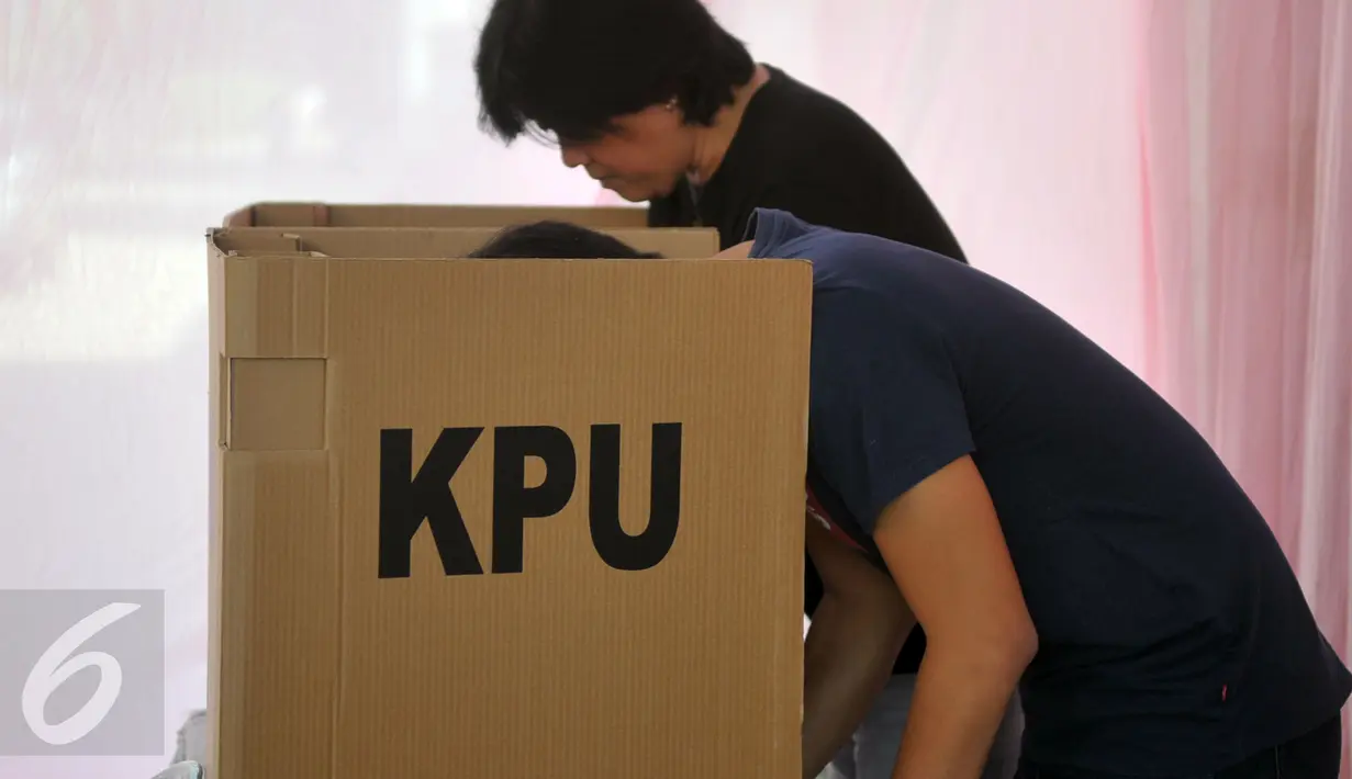 Warga mencoblos surat kertas suara di bilik saat menggunakan hak pilih di TPS 12, Kelurahan Cilenggang, Tangerang Selatan, Rabu (9/12). Aksi Barongsai ikut menyemarakan pemungutan suara Pilkada Serentak di TPS tersebut. (Liputan6.com/Faisal R Syam)