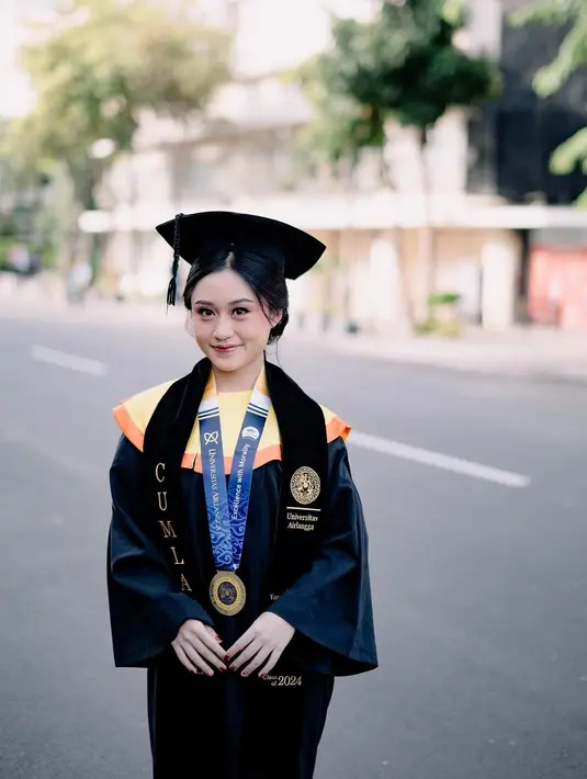 Penantian 3,5 tahun, kebahagiaan tak henti terpancar di wajah Vanessa Audy berfoto dengan atribut lengkap wisuda mulai dari toga, jubah, dan selempangnya. Kuliah di Unair, Surabaya adalah impian Vanessa Audy sejak lama. Lewat instastory terbarunya, Audy ungkap jika ia dulu selalu senang jika melewati Unair ketika jalan-jalan ke Surabaya. Audy juga sering sebut jika Unair adalah kampusnya meski saat itu belum menjadi mahasiswa. (Liputan6.com/IG/@audyvanessa)