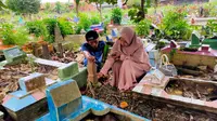 Rusdi-Soimah, saat berziarah ke makam anaknya AM, santri Pondok Modern Darussalam Gontor Ponorogo Jatim, yang meninggal dunia diduga akibat kekerasan maut di lingkungan ponpes (Liputan6.com / Nefri Inge)