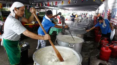 Sejumlah orang mengaduk Bubur Lambuk di desa Kampung Baru, Kuala Lumpur, Malaysia, Kamis (1/6). Bubur Lambuk adalah bubur yang terbuat dari beras dengan campuran rempah dan sayuran. (AP/Daniel Chan)