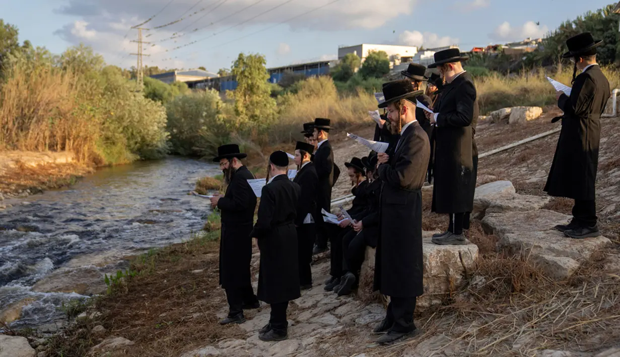 Yahudi ultraortodoks berpartisipasi dalam upacara Tashlich di tepi sungai dekat Beit Shemesh, Israel, Rabu (20/9/2023). Tashlich, yang berarti 'membuang' dalam bahasa Ibrani, adalah praktik di mana orang Yahudi pergi ke perairan besar yang mengalir dan secara simbolis 'membuang' dosa mereka dengan melemparkan sepotong roti atau makanan serupa ke dalam air. (AP Photo/Ohad Zwigenberg)