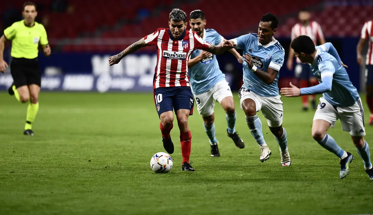 Penyerang Atletico Madrid,  Angel Correa (tengah) berlari membawa bola dari kawalan para pemain Celta Vigo pada pertandingan lanjutan La Liga Spanyol di stadion Wanda Metropolitano di Madrid, Spanyol, Selasa (9/2/2021). Atletico bermain imbang atas Celta Vigo 2-2. (AP Photo/Jose Breton)