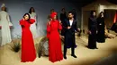Desainer Turki Rasit Bagzibagli (tengah) berinteraksi dengan model Alima Aden saat peragaan busana di Istanbul, Turki (26/3). Meski berhijab, Halima Aden tidak merasa berbeda dari model lainnya di Amerika. (AP Photo / Lefteris Pitarakis)