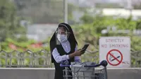 Seorang biarawati memakai masker dan pelindung wajah di Bandara Internasional Manila, Rabu (17/3/2021). Warga asing dan warga Filipina yang kembali luar negeri tidak akan dapat memasuki negara itu dari 20 Maret hingga 19 April, kata gugus tugas virus corona. (AP Photo/Aaron Favila)